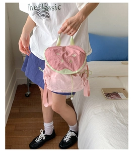 Detail of pink and green watermelon-shaped backpack with cute seed embroidery for girls