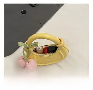 Detail view of mini crescent bag interior with knot handle and pink cherry charm