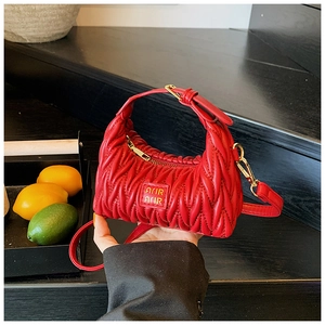 Detailansicht der roten gesteppten Mini-Handtasche mit gerafftem Design und Metall-Logo