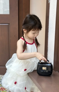 Détail du mini sac pour fille avec texture crocodile noire et boucles métalliques dorées