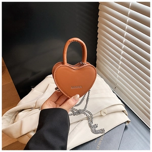Gros plan d'un mini sac à bandoulière en forme de cœur en similicuir caramel avec chaîne