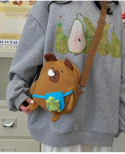 Détail du sac bandoulière Capybara avec pendentif tortue en peluche sur sangle toile
