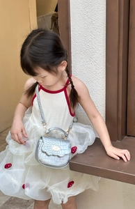 Mini sac argenté pour fille avec gaufrage crocodile et bandoulière amovible porté par l'enfant