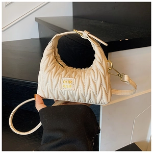 Detailansicht der cremeweißen Mini-Schultertasche mit goldener Hardware und Logo-Prägung