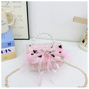 Detail of pink tweed bag with organza bow, pearl handle, and feather accents
