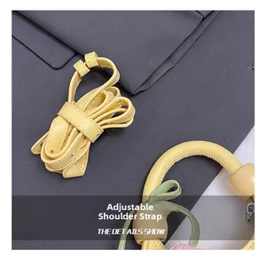 Close-up of adjustable faux leather shoulder strap with silver buckle on yellow bag