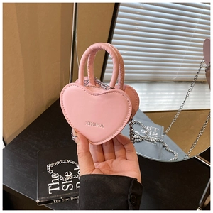 Vue détaillée d'un mini sac à bandoulière rose en forme de cœur avec chaîne en argent
