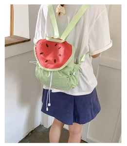 Detail showing the watermelon pattern backpack with a green base and red seeds design