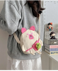 Détail du sac bandoulière en toile capybara avec yeux en cœur et peluche tortue