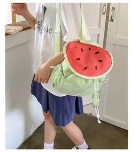 Detail view of watermelon-shaped drawstring backpack with embroidery and green straps