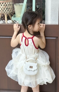 Détail d'un sac à main blanc pour enfant avec motif crocodile et boucle dorée chic