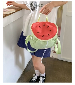 Lifestyle shot of a watermelon-shaped drawstring backpack with vibrant red and green colors