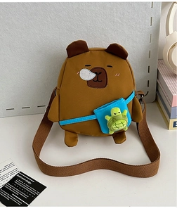 Détail du sac à bandoulière ours marron avec un accessoire tortue en peluche verte sur le devant
