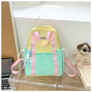 Detail of colorful nylon kids backpack featuring three-tone stitching and side drawstring pocket