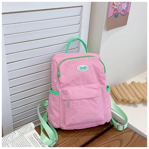 Detail of pink and green candy-colored kids backpack with TOCHASU HAPPY logo label
