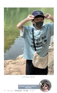 Close-up of beige canvas dumpling crossbody bag on a child outfit with blue t-shirt