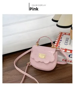 Détail du mini sac à main rose avec texture crocodile et anneau métallique doré