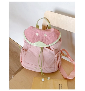Detail of pink and green kids backpack with guava embroidery and drawstring closure