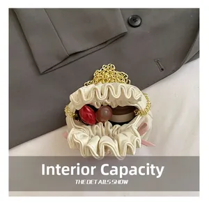 Internal capacity of mini white pleated cloud bag showing space for lipstick and makeup