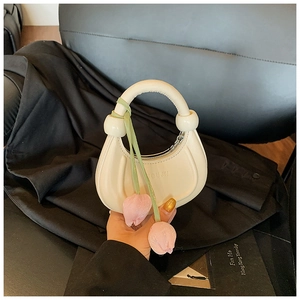 Detail of cream mini crescent handbag with tulip charms and embossed YOUJN logo