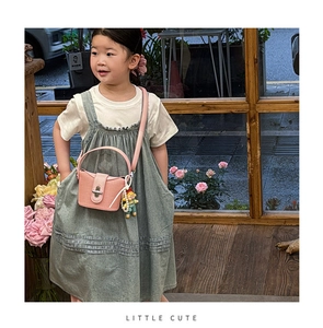 Detail der rosa gewebten Mini-Handtasche für Mädchen mit süßem Anhänger und Schloss