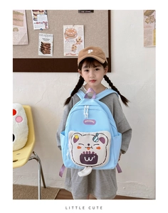 Detail of light blue children's backpack featuring a cute 3D cartoon bear pocket