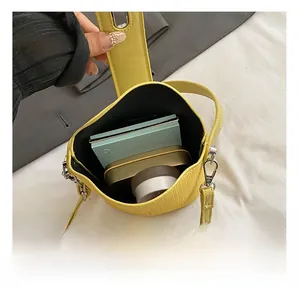 Detailansicht der gelben Beuteltasche mit Fokus auf das geräumige Innenfach für Zubehör