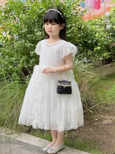 Detail of girls' white layered mesh princess dress with pearl neckline and puff sleeves