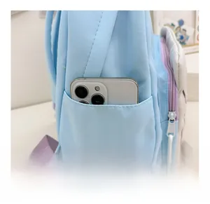 Detail view of the light blue backpack side pocket holding a large smartphone