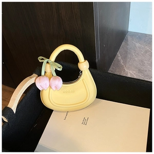 Detail of yellow crescent handbag with pink tulip charm and embossed logo