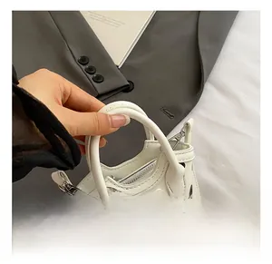 Détail du mini sac à pois avec poignée en perles et décoration de nœud en dentelle