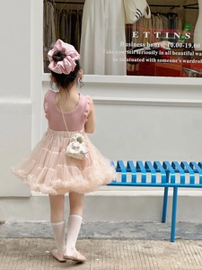 Close-up of pink layered tutu skirt and white chain mini bag with sweet bow detail