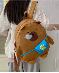 Detail of a brown Capybara backpack for kids featuring a green turtle pendant