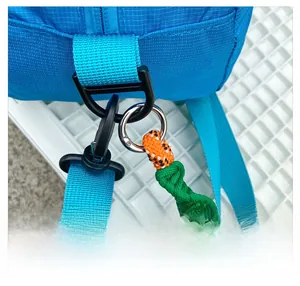 Macro detail of blue nylon shoulder bag featuring woven rope strap and durable D-ring