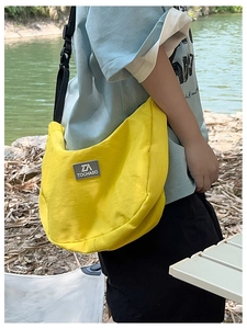 Detailed close-up of a bright yellow nylon crescent crossbody bag for kids in natural light