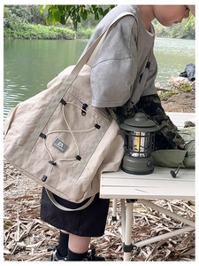 Detail of beige travel tote featuring elastic drawstring design and outdoor camping aesthetic