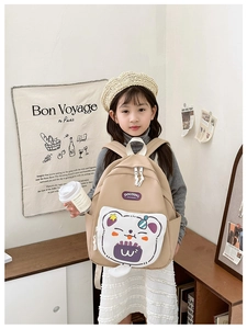 Detail of cute cartoon bear pattern on durable khaki school bag with DOUDING logo