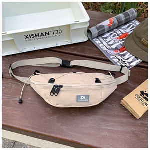 Dettaglio della borsa a tracolla in nylon beige con lacci elastici e cinturino regolabile