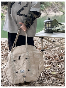 Close-up of khaki waterproof nylon travel bag with elastic drawstrings and side zipper