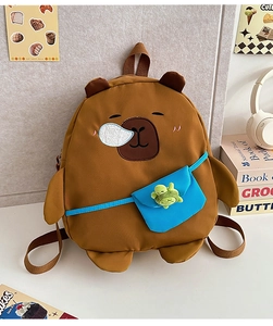 Close-up of cute brown cartoon backpack with embroidered eyes and plush turtle accessory