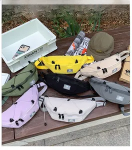 Dettaglio di marsupi colorati in nylon per bambini con corde su una panchina