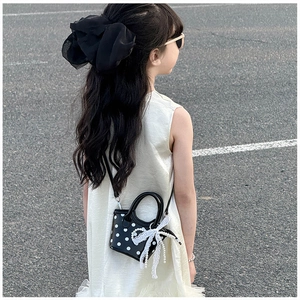 Détail du mini sac pour filles à pois avec nœud en dentelle et chaîne de perles chic