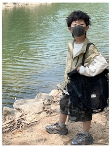 Detail of a large capacity black drawstring travel bag for kids in an outdoor setting