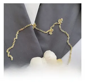 Détail du sac bandoulière jaune avec nœud blanc et bandoulière chaîne dorée
