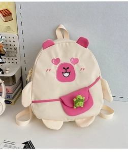 Detail of cream Capybara backpack for kids featuring pink ears and green turtle doll