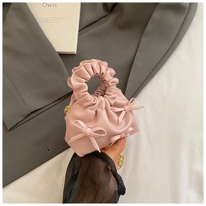Close-up of pink cloud bag showing bow details and scrunchie handle with gold chain
