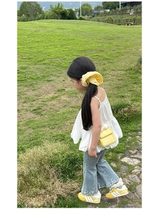 Photo de fille avec un sac bandoulière boîte de lait jaune et un jean évasé bleu