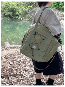 Detail of army green nylon travel bag with elastic drawstring and adjustable strap