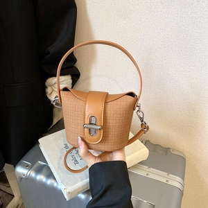Details der Vintage-Eimertasche mit Webstruktur und silbernem Drehverschluss in Karamell