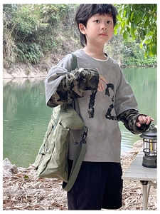 Outdoor camping scene showing kids grey long sleeve tee with camo sleeves and green bag